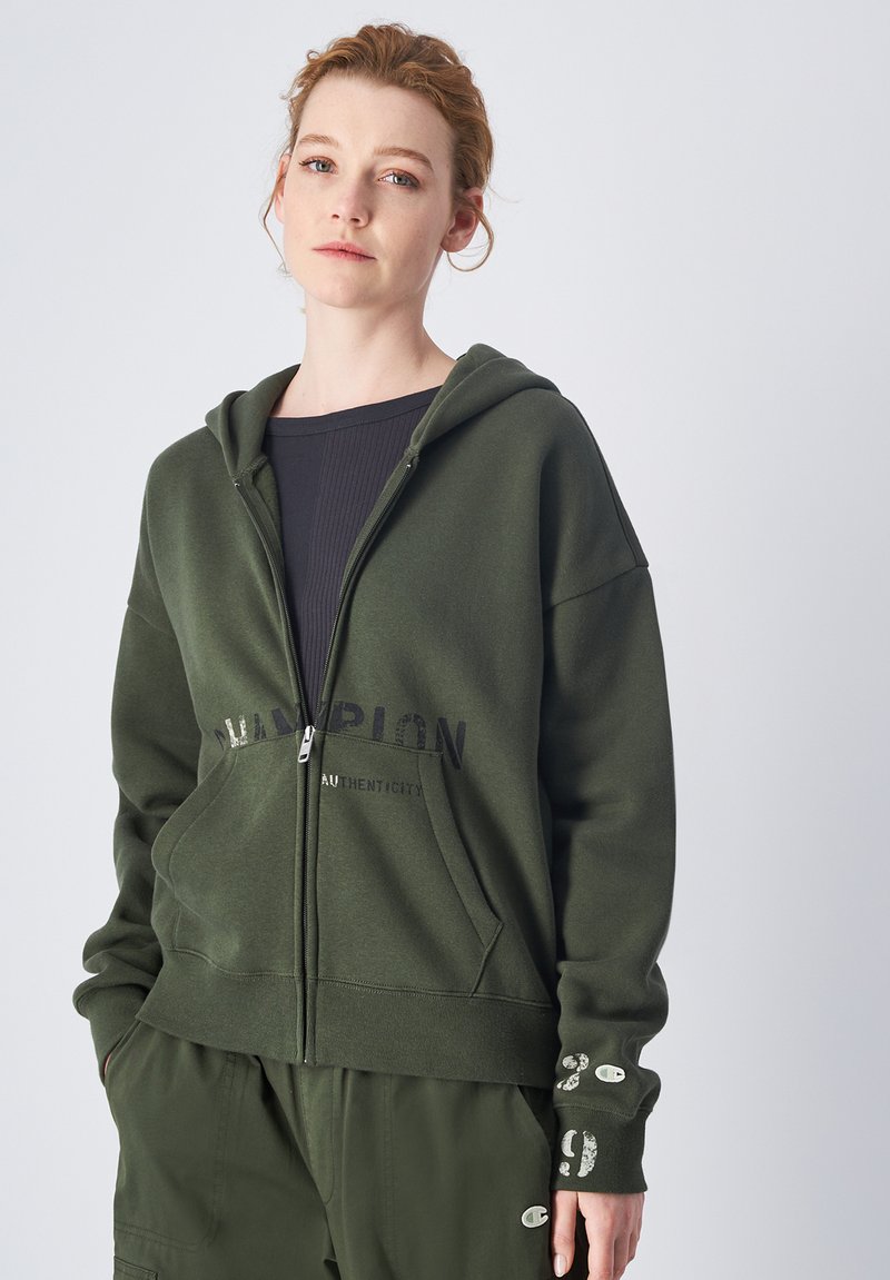 Grüne Zip-Hoodie aus weichem Baumwollmaterial mit einem Logo-Druck auf der Vorderseite. Verfügt über eine Kapuze, Kängurutaschen und detaillierte Bündchen.