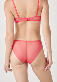 Set di lingerie rosa trasparente composto da un reggiseno liscio con spalline regolabili e pantaloni alti abbinati con finitura senza cuciture.