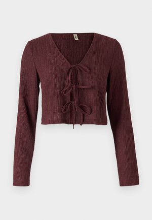 Top cropped de mangas longas em burgundy, em tecido texturizado, com um decote em V profundo e detalhe de laço na frente. Apresenta um design ajustado.