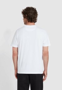 Weißes Baumwoll-T-Shirt mit kurzen Ärmeln, Rundhalsausschnitt und geradem Saum. Glatte Textur, minimalistisches Design, keine sichtbaren Muster oder Akzente.