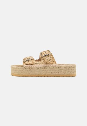 Sandales plateformes en paille tressée avec deux sangles ajustables, dotées de boucles métalliques. La semelle extérieure est beige avec un bord texturé pour une meilleure adhérence.