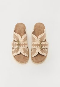 Sandales à enfiler beiges avec des accents brodés, des brides larges et une boucle. Semelle texturée avec des détails tressés autour des bords.