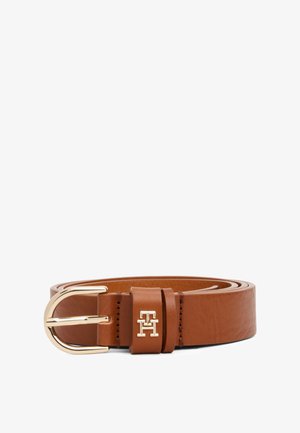 Ceinture en cuir marron avec boucle dorée et initiales métalliques décoratives sur la boucle de la ceinture, roulée à plat sur un fond blanc.