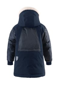 Giacca invernale blu navy con cappuccio foderato in pelliccia sintetica, materiali lisci e strutturati, ampio pannello posteriore e tasca laterale con dettaglio del logo.