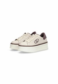 Sneaker color crema con un accento lucido di un profondo bordeaux scuro, dotati di una suola piatta, punta rotonda e tessuto testurizzato attorno alla caviglia.