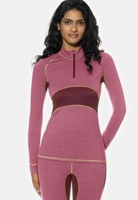 Haut de sport à manches longues rose avec des accents marron, doté d'une fermeture éclair à quart de longueur sur le devant, d'un tissu texturé et de détails de surpiqûres contrastantes.