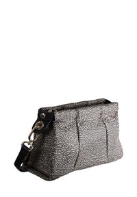 Gepunktete schwarz-weiße Handtasche mit strukturierter Oberfläche, rechteckiger Form, zwei seitlichen Taschen und einem schwarzen Riemen mit goldfarbenen Beschlägen.