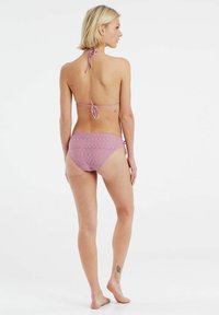 Šviesiai violetinis bikini komplektas, pagamintas iš elastingos medžiagos; halter stiliaus viršus su raišteliais kakle ir nugaros pusėje, atitinkantis bikini apatinis trikotažas su tekstūruotu raštu ir šoninėmis raišteliais.