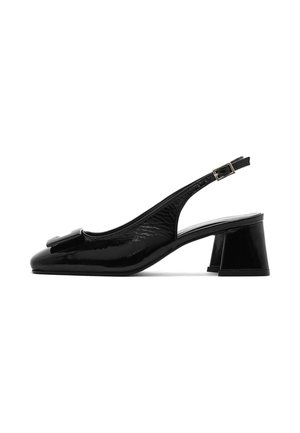 Scarpa slingback in vernice nera con tacco basso a blocco, punta affilata e dettaglio decorativo a fiocco sul fronte. Cinturino alla caviglia regolabile.