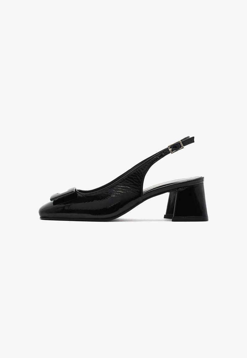 Schwarzer Lackleder-Slingback mit niedrigem Blockabsatz, spitzem Zehenbereich und dekorativem Schleifchen vorne. Verstellbarer Knöchelriemen.