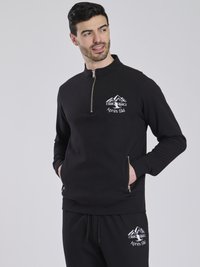 Schwarze Zip-Up Sweatshirt mit langen Ärmeln, Viertel-Reißverschluss-Kragen, gesticktem Bergdesign und seitlichen Reißverschlusstaschen. Kombiniert mit schwarzen Sweatpants.