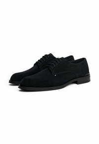 Donkerblauwe suède nette schoenen met een ronde neus, vetersluiting en contrasterende stiksels. Voorzien van een gladde zwarte zool.