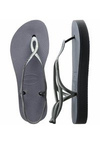 Infradito grigi in gomma con soletta testurizzata e cinturini intrecciati. Suola nera, design open-toe e senza ulteriori decorazioni.