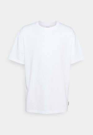 Bijela pamučna majica s kratkim rukavima, okruglim izrezom i opuštenim krojem. Ima malu oznaku branda sa strane. Glatka tekstura.