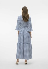 Vestido largo a rayas en azul y blanco, con mangas acampanadas, dobladillo en capas y cintura ajustada. El tejido parece ligero y suave.