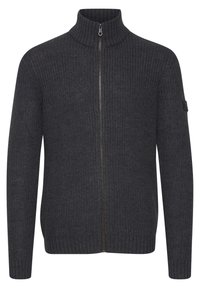 Pull en maille gris foncé à fermeture éclair, doté d'un col haut, de poignets côtelés et d'une fermeture éclair lisse. Comprend une petite patch avec logo sur la manche.