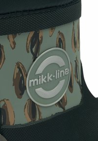 Zöld gumicsizma barna körmintával, texturált fekete talppal és feltűnő ezüst "mikk-line" logóval.