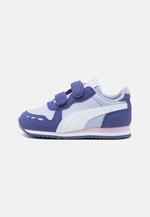 Zapatilla Puma infantil en morado y blanco con dos correas de velcro y detalles rosas sobre fondo blanco.
