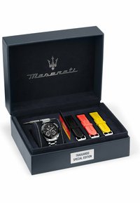 Maserati Traguardo Special Edition horloge met een zwarte wijzerplaat, zilveren armband en drie verwisselbare banden in zwart, rood en geel in een presentatiebox.