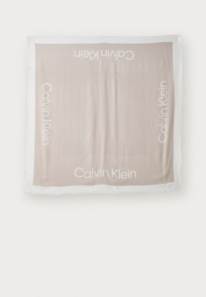 Calvin Klein scarf in soft beige fabric, featuring white logo text at corners. Square shape with slight fraying along edges.