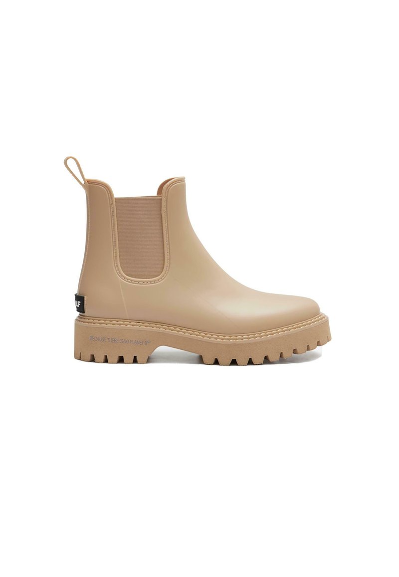 Botas Chelsea de goma beige con paneles laterales de elastano texturizados, tira en la parte trasera y suela de goma gruesa. Presenta una marca en el talón.