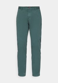 Chino vert sarcelle coupe slim avec passants de ceinture, bouton devant, poches latérales et jambes droites sur fond blanc uni.