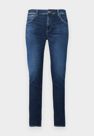 Jeans slim-fit blu scuro con bottone frontale, cerniera e design a cinque tasche, mostrati su uno sfondo chiaro semplice.
