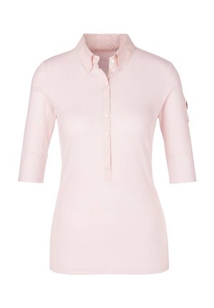 Polo rose clair à manches courtes avec col et patte boutonnés, présentant une silhouette ajustée et une petite poche sur la manche gauche.