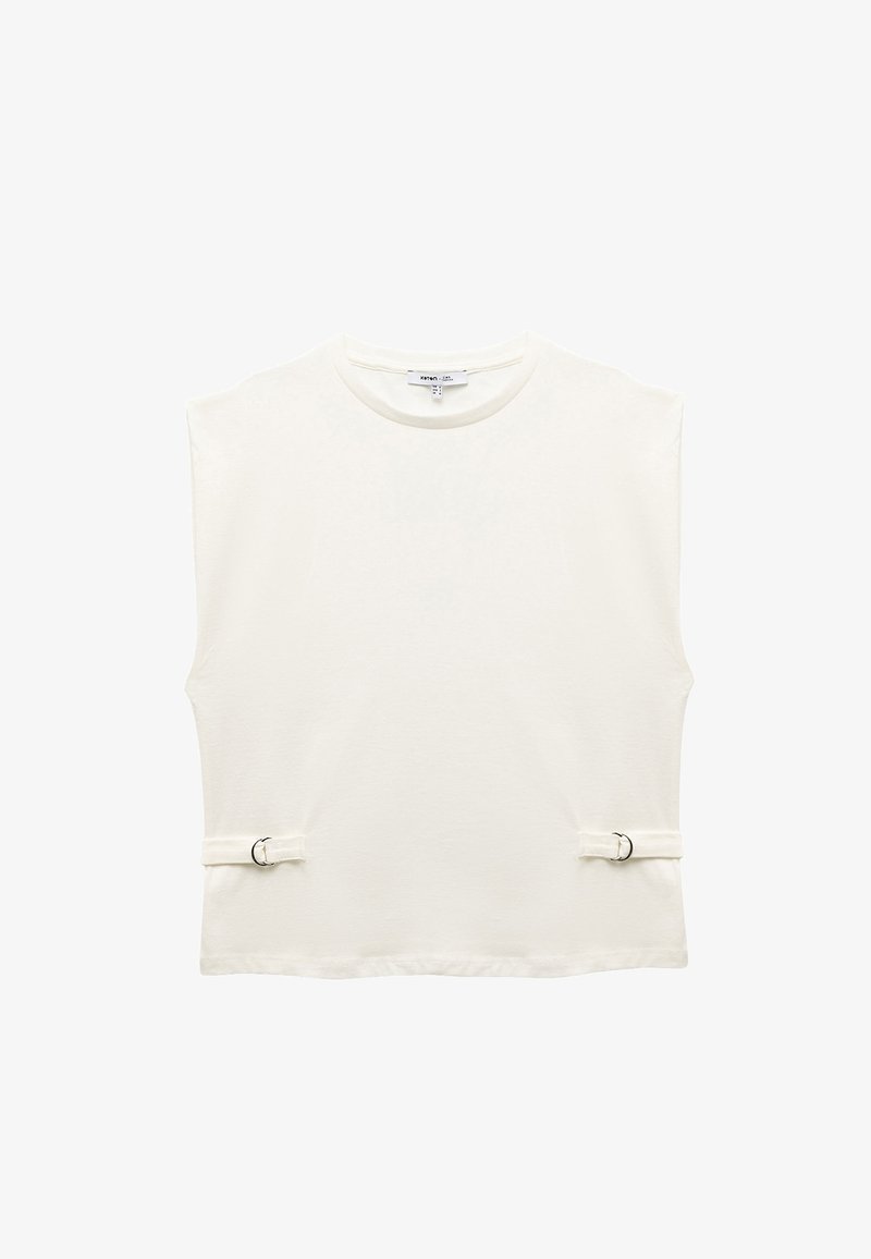White sleeveless top made of soft fabric with a crew neck. Features two fabric straps with metal rings on the sides for adjustment.