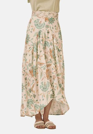 Falda maxi en beige claro con estampado floral en verde y naranja. Presenta un diseño plisado y una cinturilla decorada. Se lleva con sandalias planas.