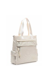 Beige textured fabric tote bag with dual top handles, front flap pocket, side zip pockets, and a decorative metal clip on front pocket zipper.