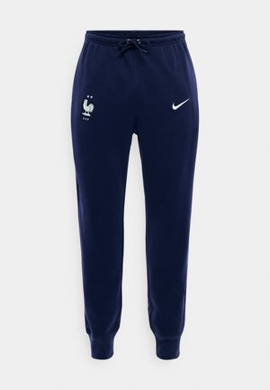 Pantaloni sportivi Nike blu navy con polsini elasticizzati, vita con coulisse, logo della nazionale francese di calcio sulla coscia sinistra e swoosh Nike sulla coscia destra.
