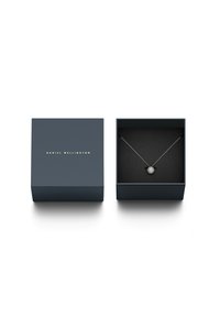 Sølvvedhængs halskæde præsenteret i en mørkeblå æske med guld "Daniel Wellington"-tekst. Sort indvendig pude viser smykket sikkert.