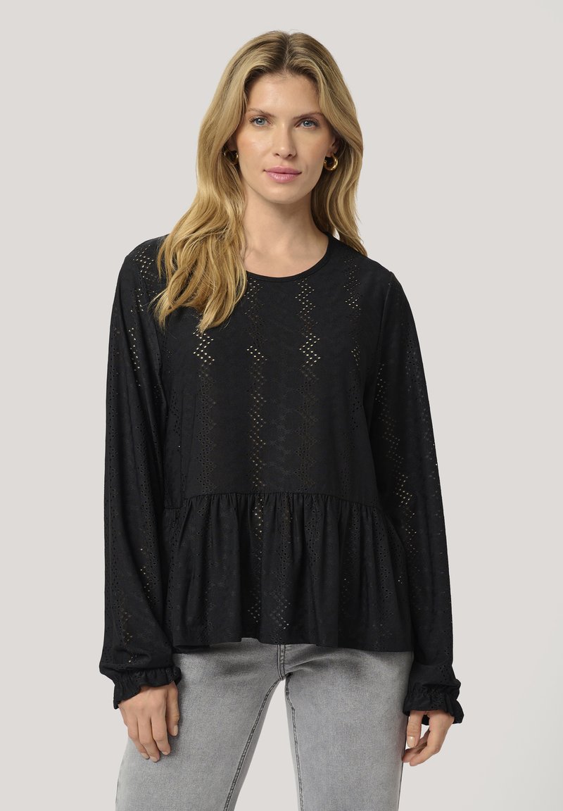 Black long-sleeve blouse with lace detailing, featuring a peplum waist and ruffled cuffs. Made of lightweight, textured fabric.