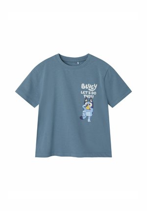 Hellblaue Baumwoll-T-Shirt mit kurzen Ärmeln, das ein Cartoon-Charakter und den Text: "BLUEY, LOS GEHT'S!" auf der Vorderseite zeigt.