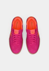 Σαπούνια από φούξια σουέντ με υφή, αντίθετη επένδυση σε νεον πορτοκαλί, καουτσούκ σόλα και επίπεδα κορδόνια.