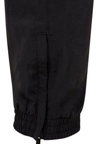 Pantaloni negri cu talie elastică și manșete la glezne, având un fermoar lateral și o textură moale. Fără modele sau accente vizibile.