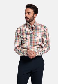 Overhemd met knoopsluiting in een geruit patroon met rode, groene, gele en blauwe vierkanten. Katoenen stof, kraag en een borstzak.