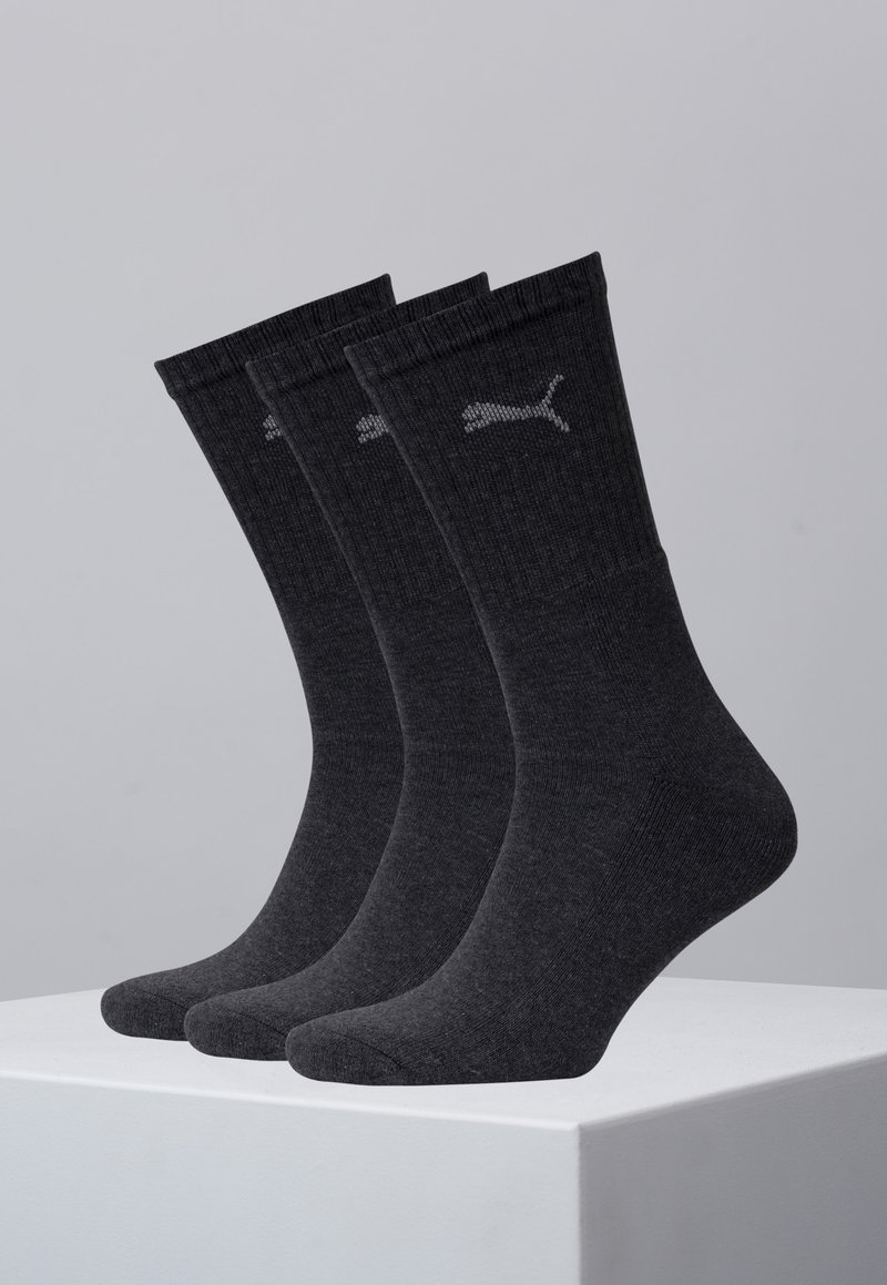 Tres pares de calcetines gris oscuro hechos de un material suave y texturizado, con un logo sutil en la parte superior y una puntera reforzada.