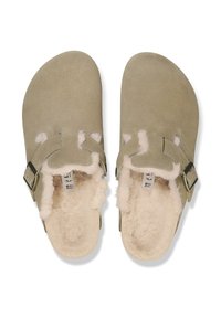 Sandalias de ante en verde apagado con un suave forro de pelaje crema. Presentan dos cortes y una hebilla de metal ajustable.
