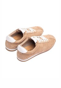 Zapatos de ante beige con acentos de cuero blanco, puntera redonda y cierre con cordones. Suelas de goma con textura ligera. Forro interior suave.