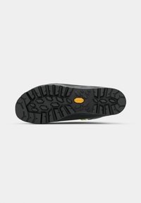 Juoda gumos batų padas su tekstūruotu raštu, turintis gilius griovelių ir "Vibram" logotipą, užtikrinančius geresnį sukibimą ir trauką.