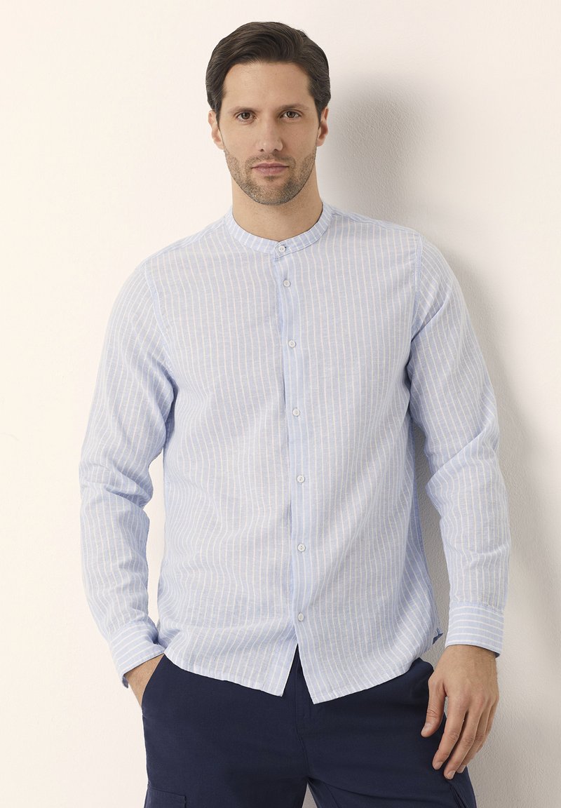 Camicia a maniche lunghe a righe blu chiaro con colletto alla coreana e chiusura con bottoni. Realizzata in un tessuto strutturato, con strisce bianche verticali.