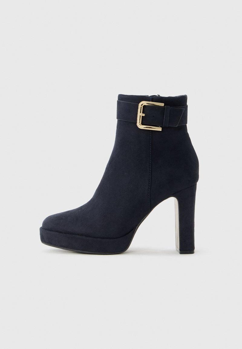 Bottine haute à talon aiguille en suede noir avec une lanière à boucle dorée et un talon large sur fond blanc uni.