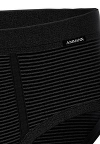 Shorts de compresión negros con un patrón texturizado y acanalado. Presentan una etiqueta de AMMANN y una cinturilla elástica suave para un ajuste seguro.