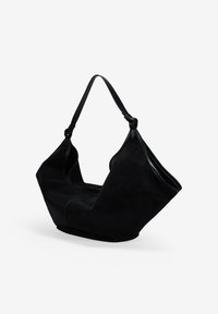 Bolso tote de ante negro con una forma única, que cuenta con una apertura amplia y una única correa ajustable para llevar. Textura suave, diseño minimalista.