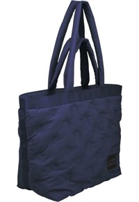 Borsa tote in tessuto blu navy con texture imbottita, doppi manici e etichetta logo cucita. Forma rettangolare, tessuto resistente, design minimalista.