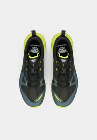 Μαύρα και γκρίζα παπούτσια τρεξίματος με υφή στην επάνω πλευρά, ανακλαστικές λεπτομέρειες και φωτεινές κίτρινες πινελιές. Διαθέτουν σχέδιο με κορδόνια και καουτσούκ σόλα.