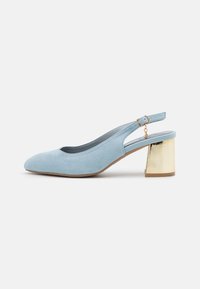 Escarpin slingback en daim bleu clair avec un bout arrondi et un talon bloc métallique doré. Doté d'une bride réglable à la cheville avec une boucle.