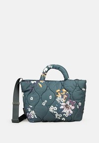 Sac matelassé bleu sarcelle foncé avec des motifs floraux, deux poignées et une bandoulière détachable. Design texturé avec une finition rembourrée.